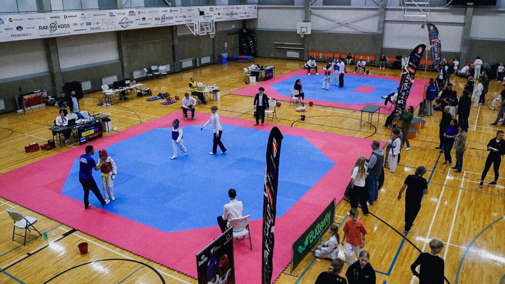 Kaks võistlejat matil kohtuniku juhendamisel
